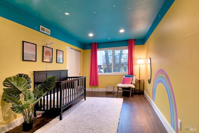 bedroom with dark wood-type flooring and a closet