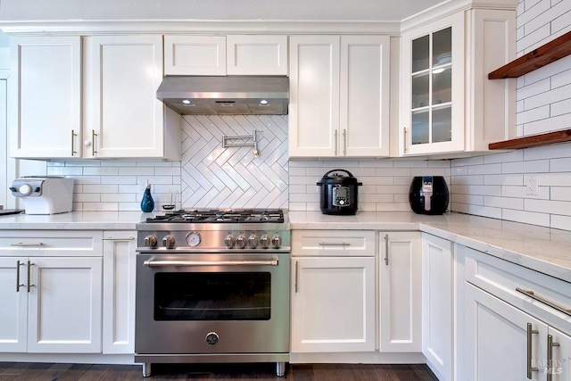 kitchen featuring ventilation hood, white cabinetry, backsplash, high end stainless steel range oven, and light stone counters