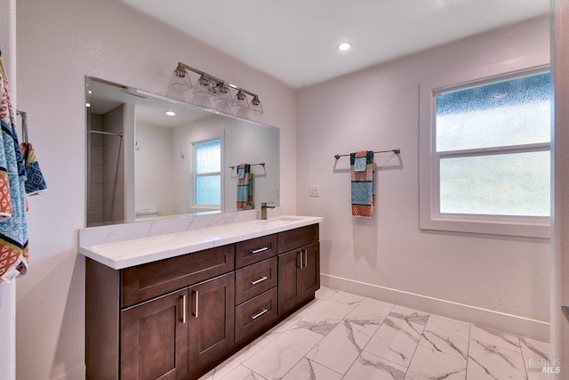 bathroom featuring walk in shower, vanity, and a wealth of natural light