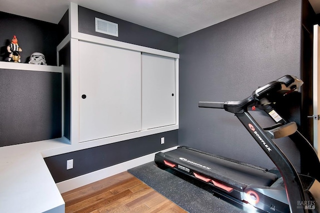 workout area with hardwood / wood-style floors