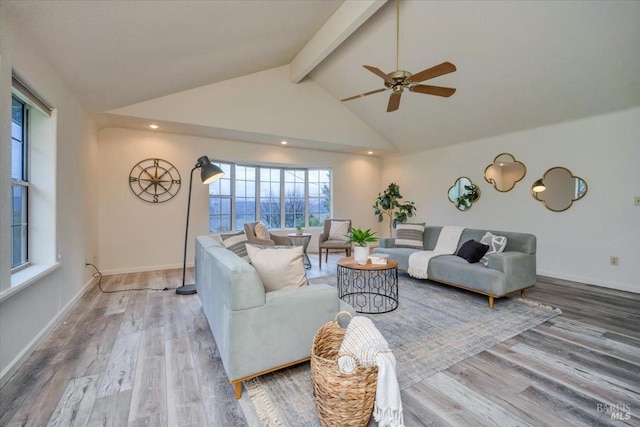 living room with ceiling fan, wood-type flooring, high vaulted ceiling, and beam ceiling