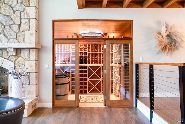 wine cellar with beamed ceiling and hardwood / wood-style floors