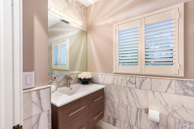 bathroom with vanity and tile walls