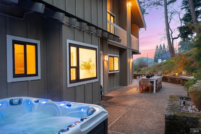 property exterior at dusk with a hot tub