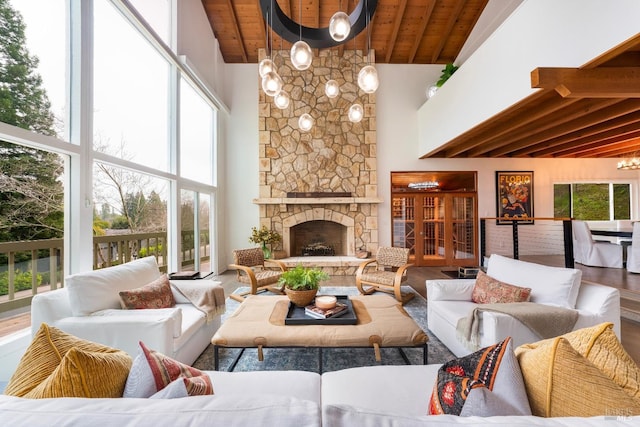 living room featuring beam ceiling, wood ceiling, a fireplace, and high vaulted ceiling