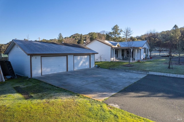 ranch-style house featuring a garage, a front lawn, and covered porch