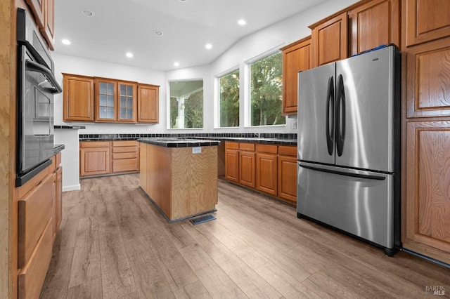 kitchen with light wood-type flooring, stainless steel appliances, and a center island