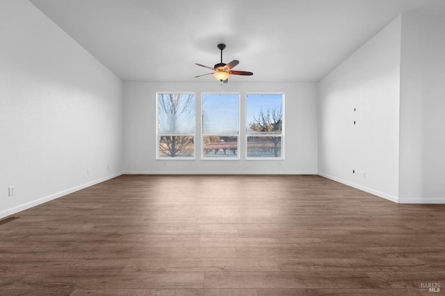 empty room with ceiling fan and dark hardwood / wood-style floors