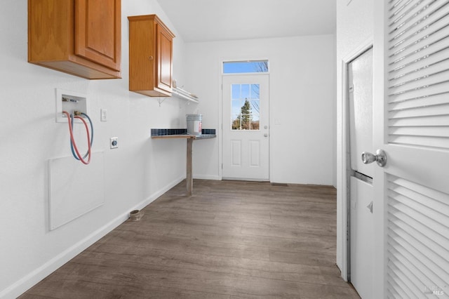 washroom featuring hardwood / wood-style floors, washer hookup, hookup for an electric dryer, and cabinets