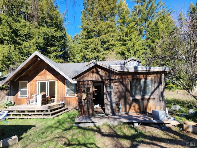 back of property with a lawn and a deck