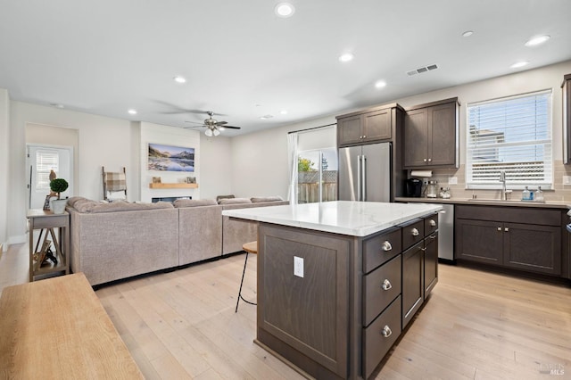 kitchen featuring light hardwood / wood-style flooring, appliances with stainless steel finishes, sink, and a center island