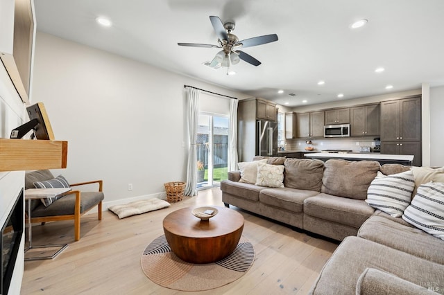 living room with ceiling fan and light hardwood / wood-style floors