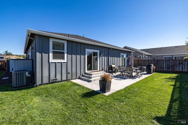 rear view of property with central air condition unit, a patio area, and a yard