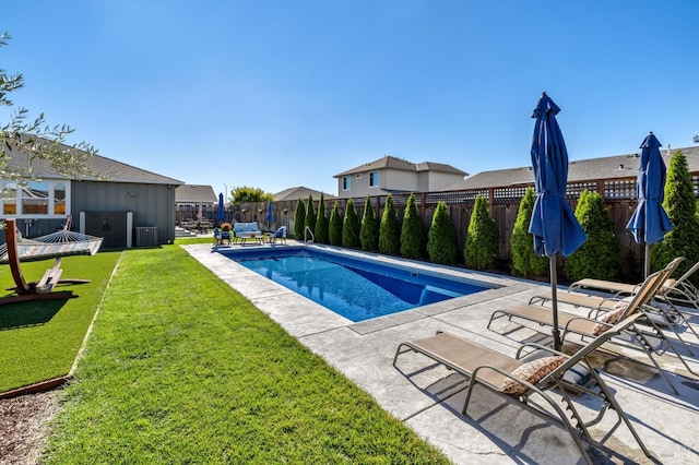 view of pool with a patio area and a yard