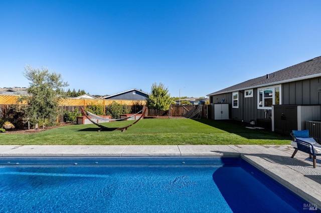 view of pool with a lawn and a patio