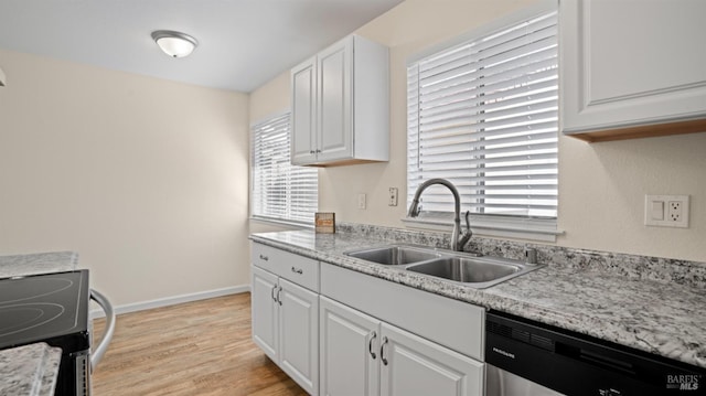 kitchen with white cabinetry, stainless steel appliances, light wood-type flooring, light stone counters, and sink