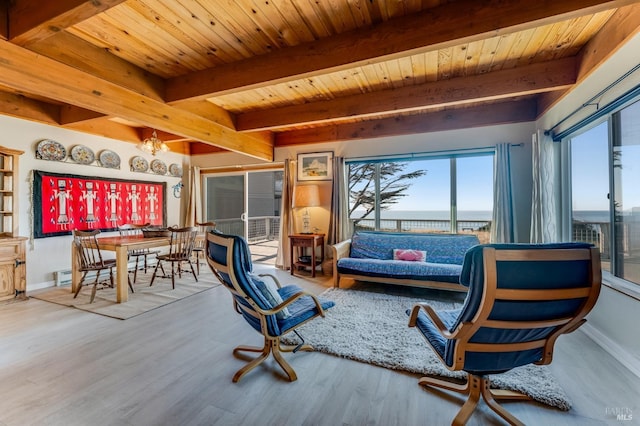 living area with wood ceiling, wood-type flooring, a chandelier, a water view, and beamed ceiling