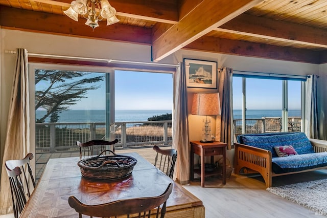 dining room with hardwood / wood-style flooring, wood ceiling, and a water view