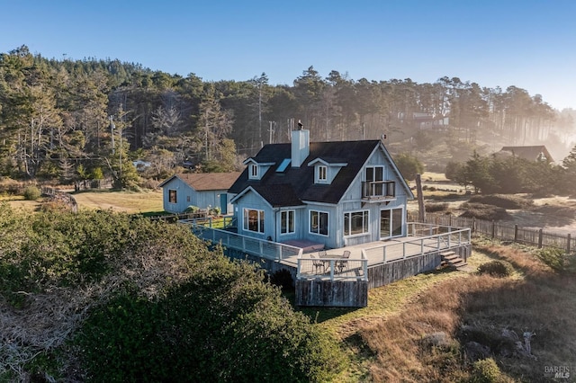 back of property featuring a wooden deck and a balcony