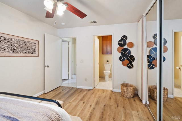 bedroom featuring ceiling fan, a closet, ensuite bathroom, and light hardwood / wood-style floors