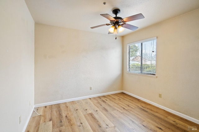 empty room with ceiling fan and light hardwood / wood-style flooring