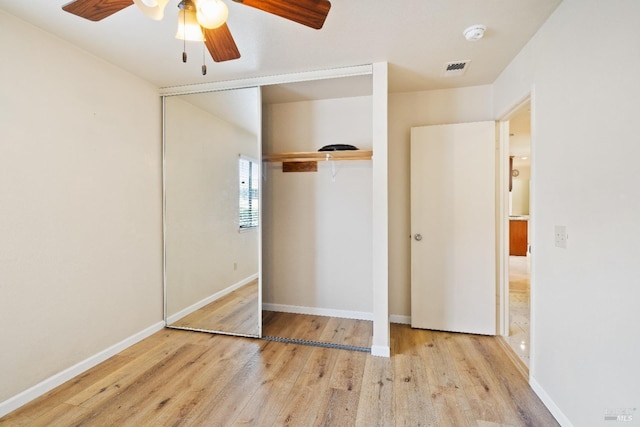 unfurnished bedroom featuring ceiling fan, light hardwood / wood-style floors, and a closet