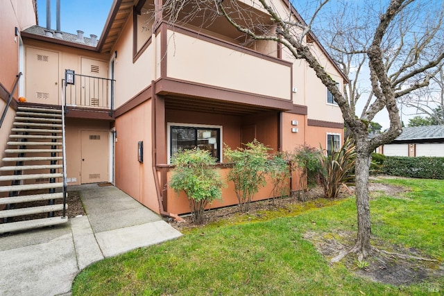 exterior space with a balcony and a lawn