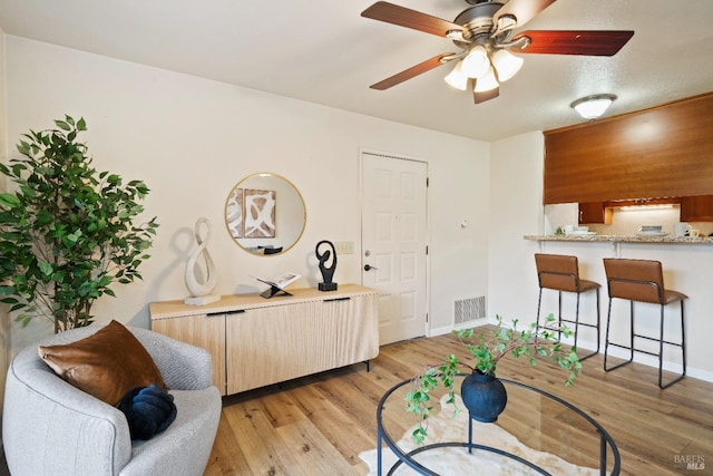 interior space with ceiling fan, light wood-type flooring, and a textured ceiling