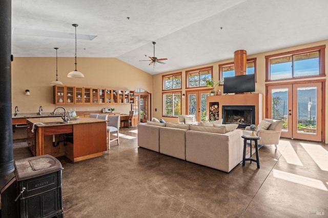 living room featuring vaulted ceiling, french doors, and ceiling fan