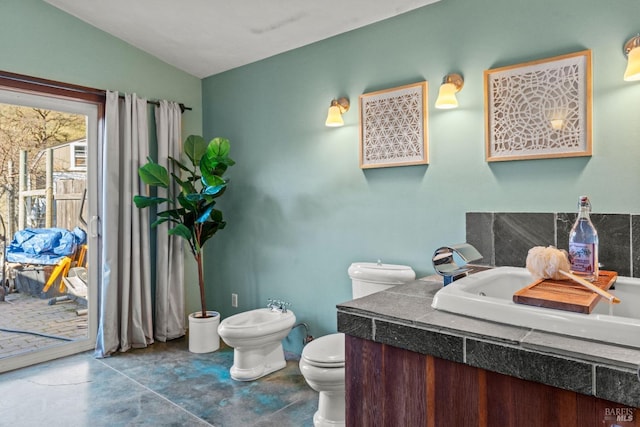 bathroom featuring a bidet, vanity, lofted ceiling, and toilet