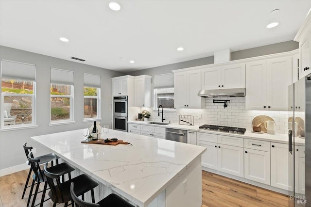 kitchen featuring white cabinetry, stainless steel appliances, and a kitchen island