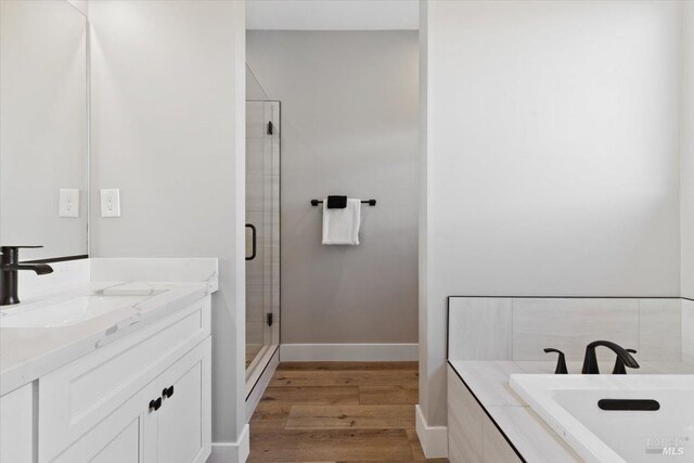 bathroom featuring vanity, wood-type flooring, and independent shower and bath