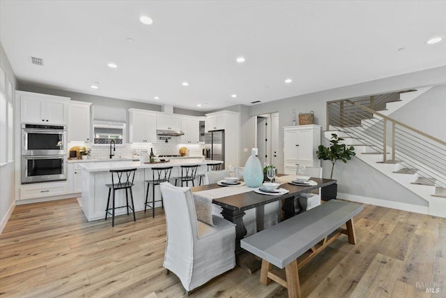 dining room featuring sink and light wood-type flooring