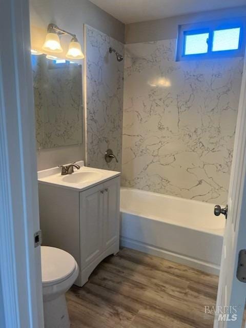 full bath featuring wood finished floors, toilet, shower / washtub combination, and vanity