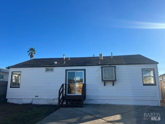back of property featuring fence, entry steps, and a patio