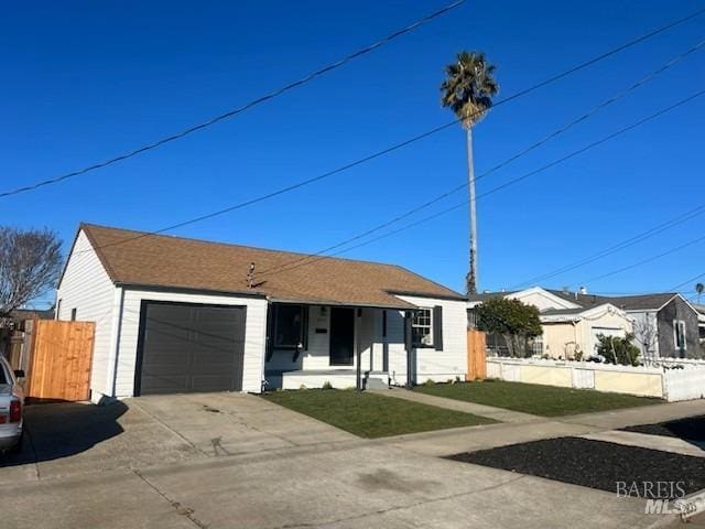 single story home with concrete driveway, a front yard, an attached garage, and fence