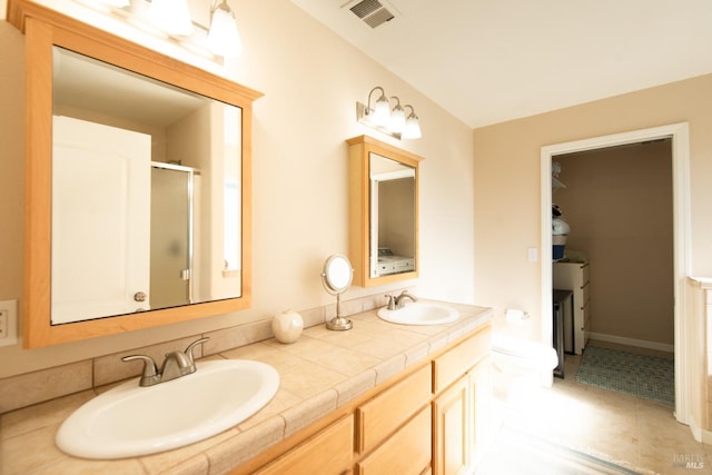 bathroom with vanity, tile patterned floors, and a shower with door