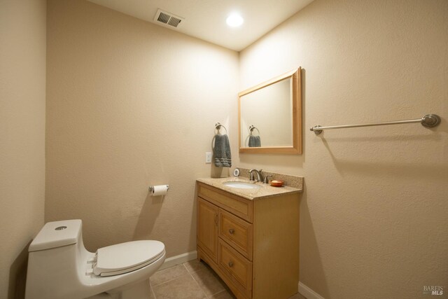 bathroom featuring a shower with door, vanity, tile patterned floors, and toilet