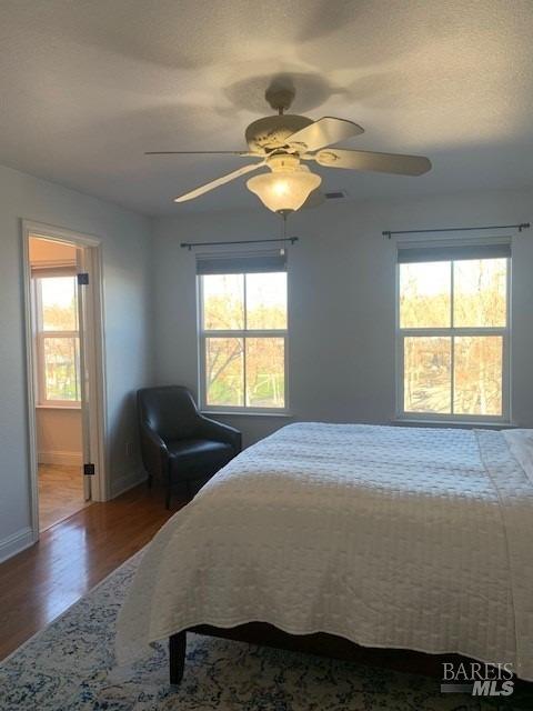 bedroom with ceiling fan and hardwood / wood-style floors