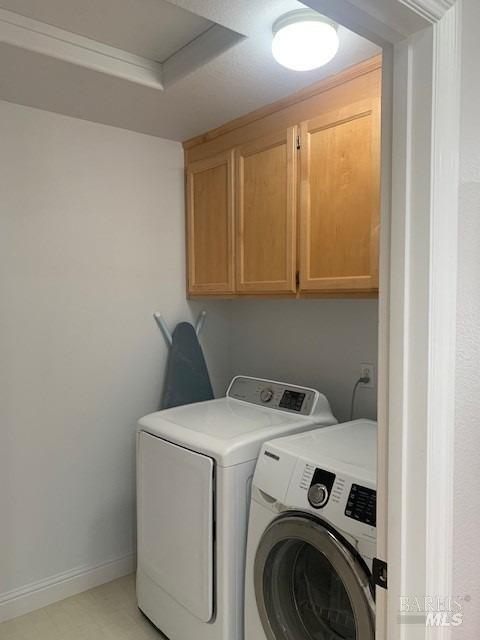 laundry area with washer and dryer and cabinets