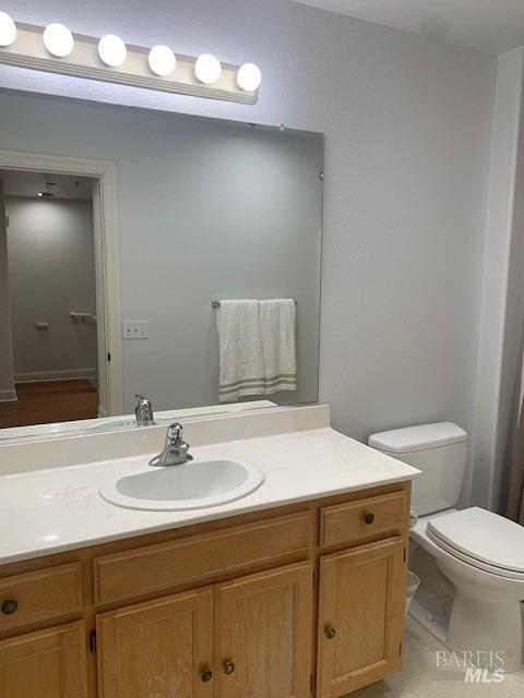 bathroom featuring toilet, tile patterned floors, and vanity