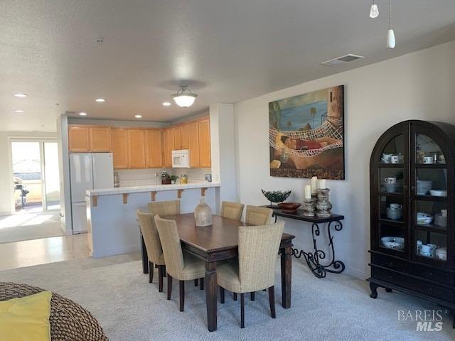 dining room featuring light carpet