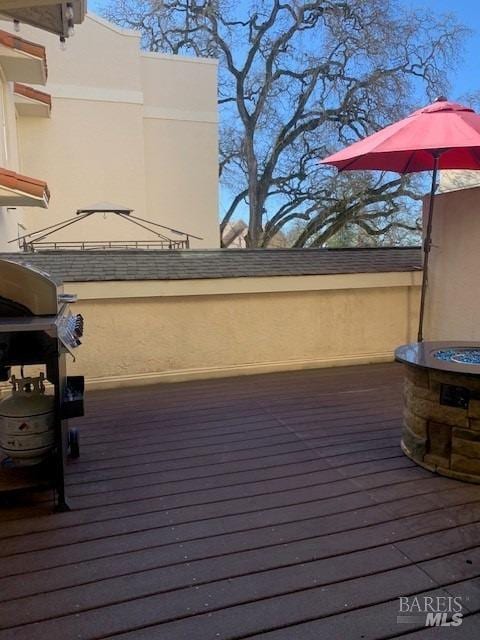 wooden deck with a grill and an outdoor fire pit