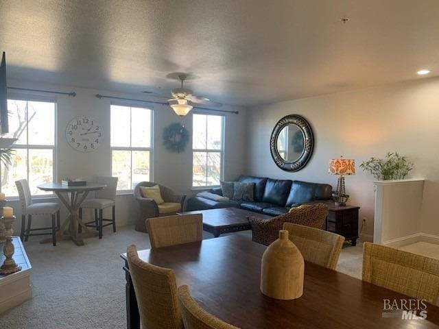 dining space with ceiling fan and carpet flooring