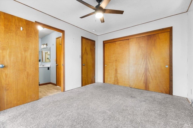 unfurnished bedroom with ceiling fan, connected bathroom, and light carpet