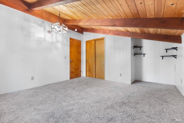 empty room featuring carpet, a notable chandelier, beamed ceiling, and wood walls