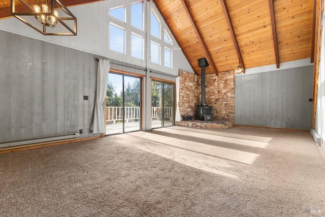 unfurnished living room with carpet, beamed ceiling, wood ceiling, a wood stove, and high vaulted ceiling