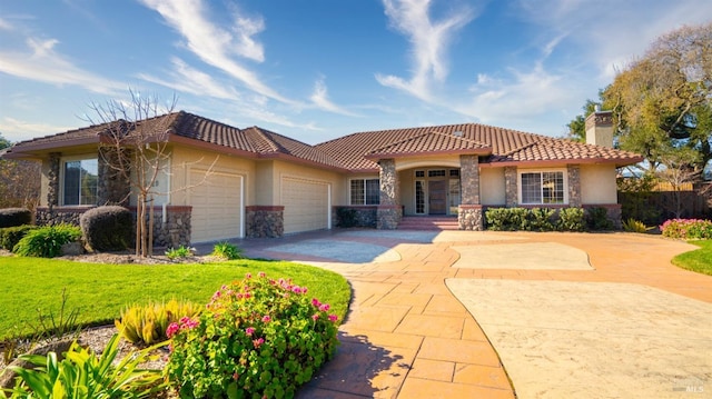 mediterranean / spanish-style house with a garage and a front lawn