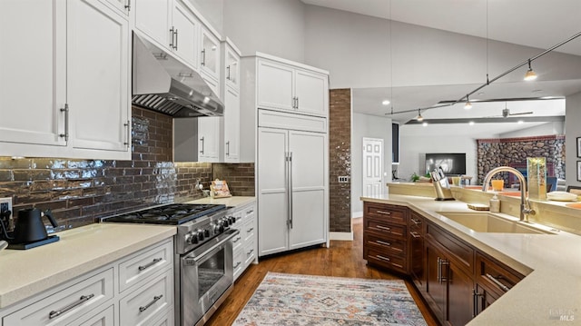 kitchen featuring premium appliances, white cabinets, dark wood-type flooring, sink, and backsplash