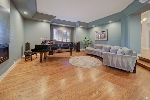 living room with a large fireplace and light hardwood / wood-style flooring